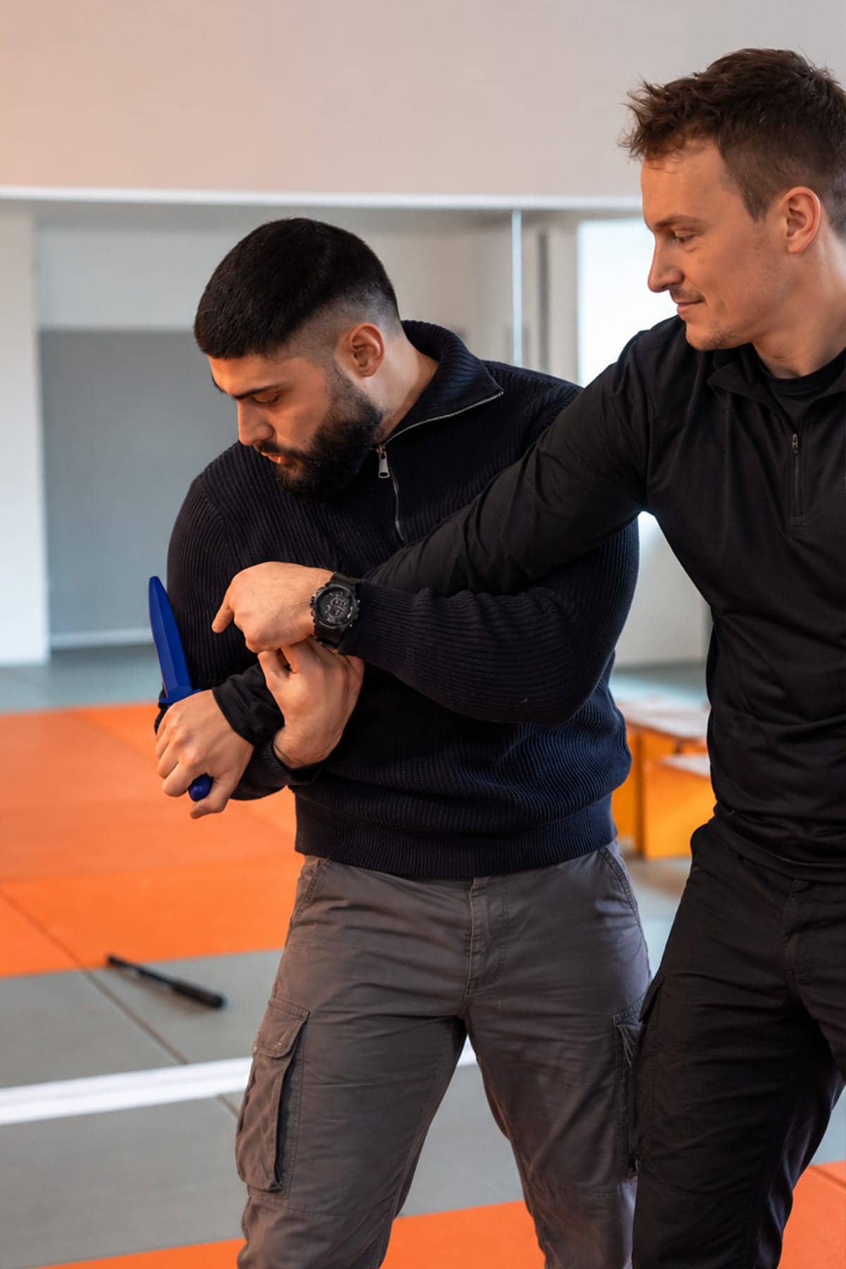 Training von Kontrolltechniken und Eigensicherung bei DERLO: Ein Trainingspartner kontrolliert den Arm mit dem Trainingsmesser.