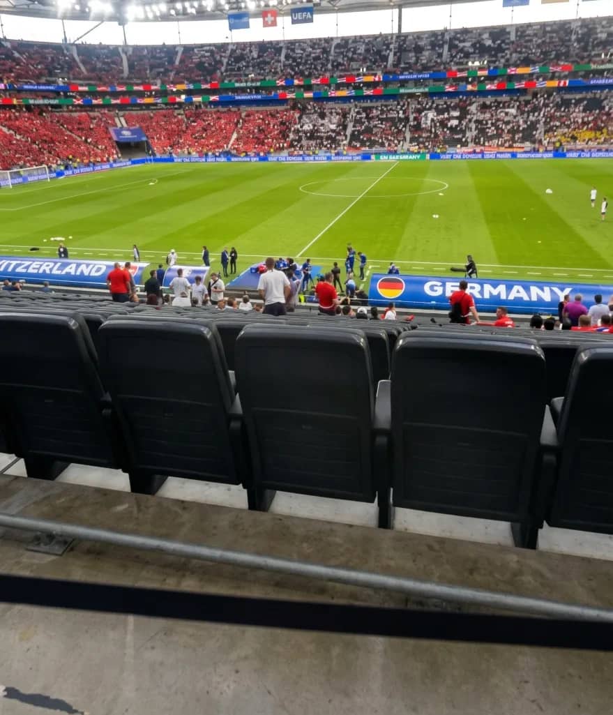 View from the stands onto the pitch and the packed tiers of a football stadium.