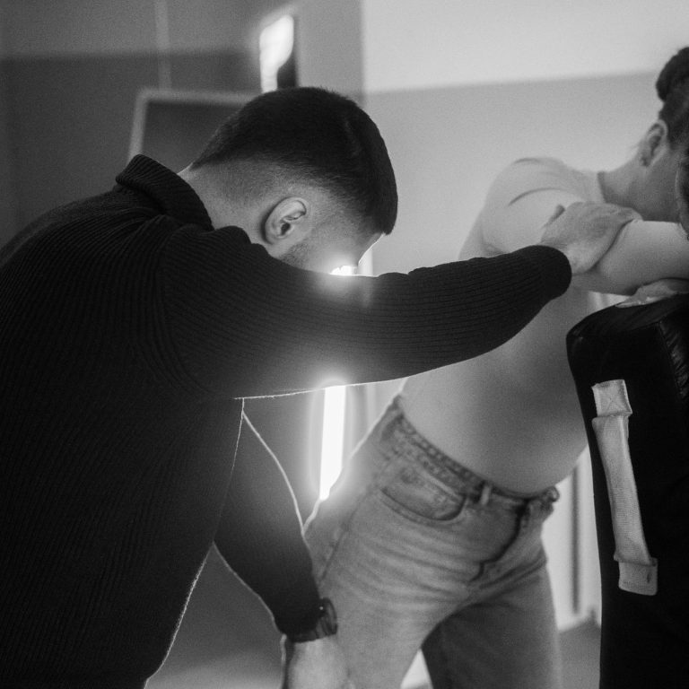 Zwei Personen in einem kreativen Foto-Setup, eine Person positioniert sich hinter der anderen.