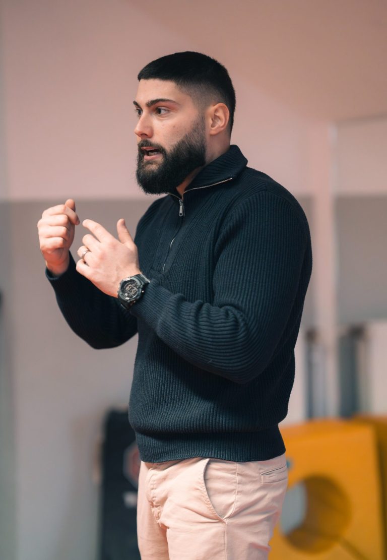 Mann mit Bart und kurz geschnittenem Haar spricht leidenschaftlich.